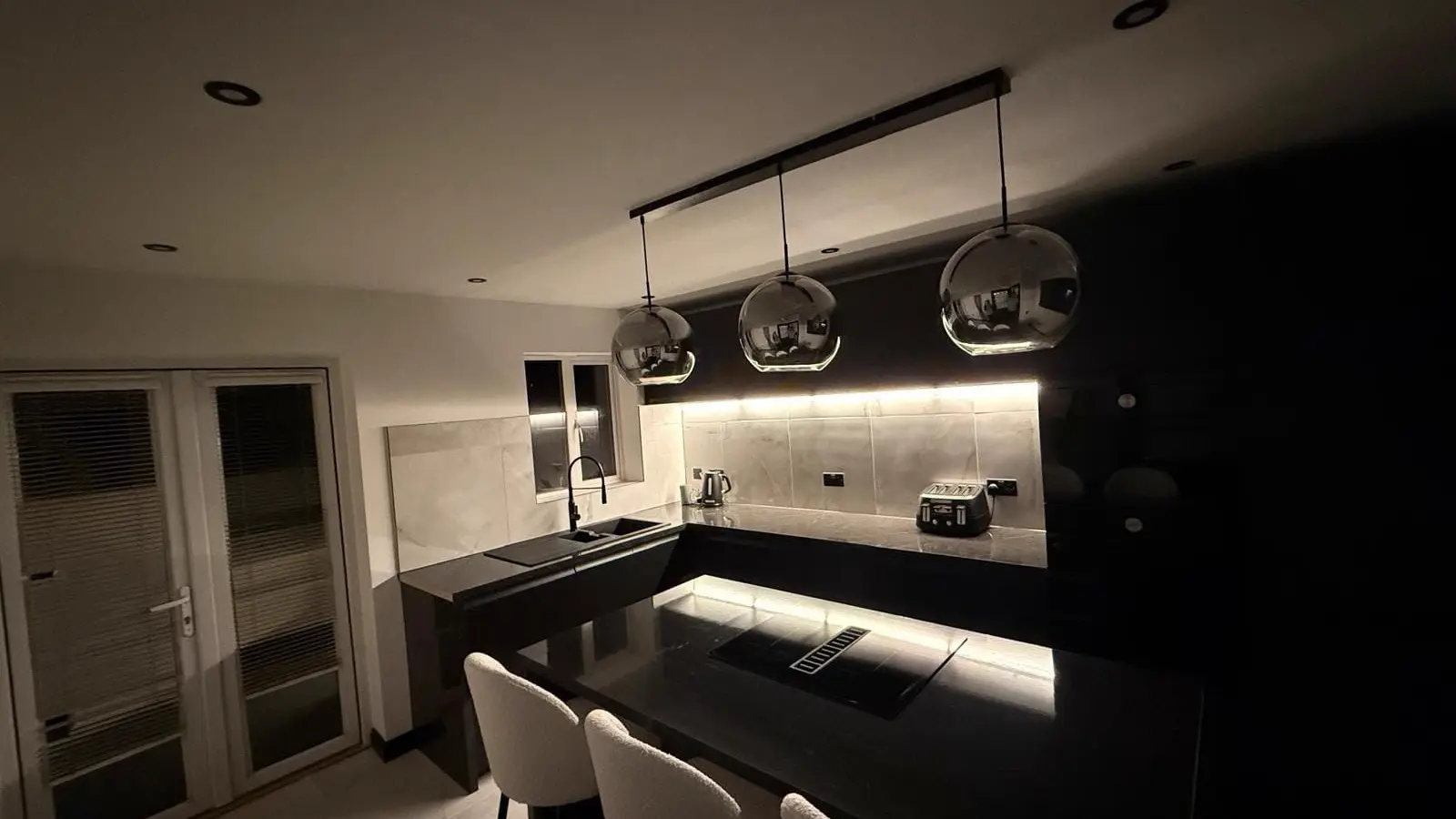 EK Joinery kitchen with island, dark cabinets and pendant lights